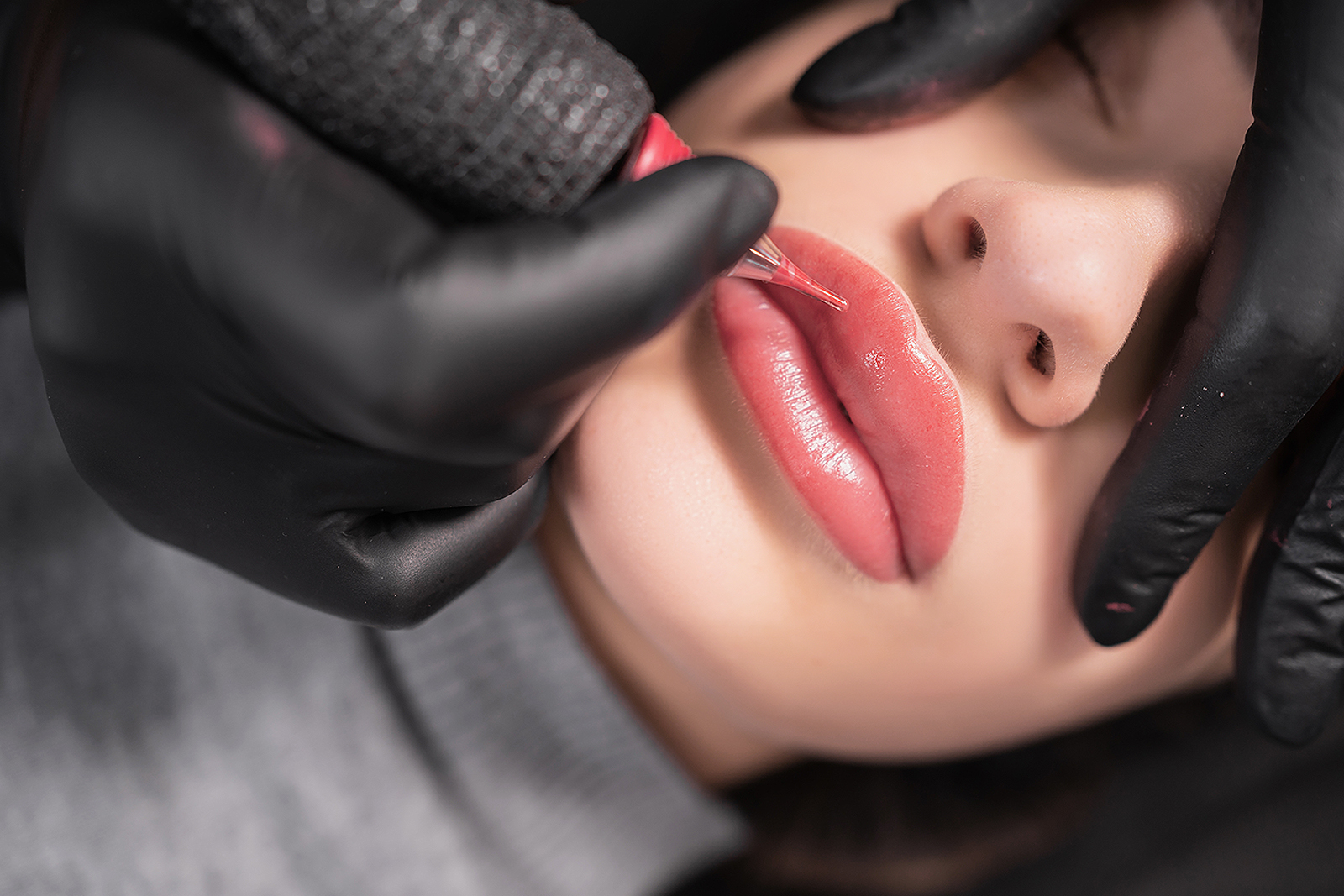 lip tattoo in a beauty salon, the process of applying coloring p